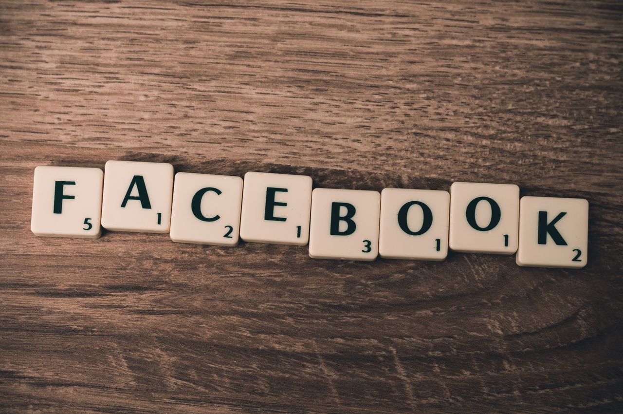 services-02 Scrabble tiles arranged to spell Facebook on a wooden backdrop, representing social media.